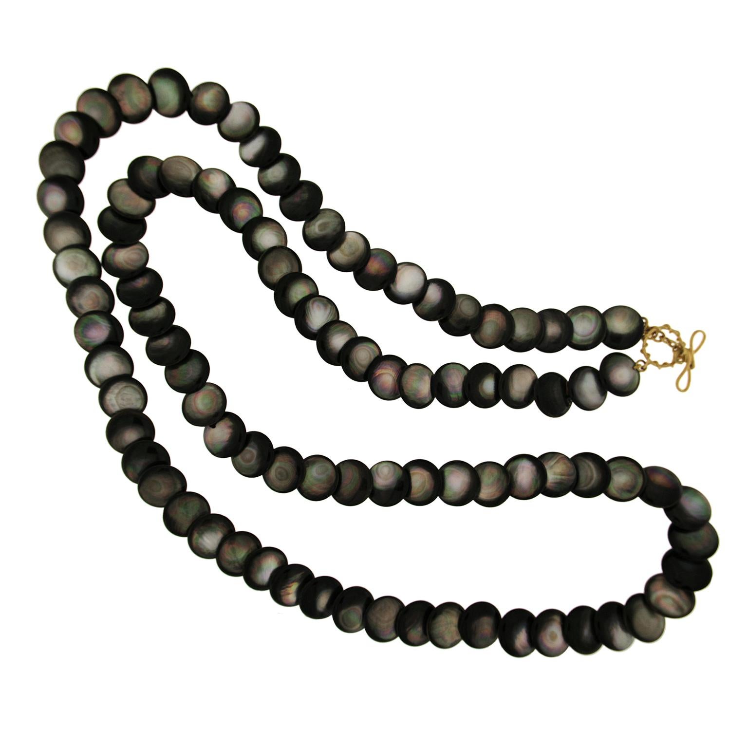 Valentin Magro Black Mother of Pearl Necklace swirls with rainbows. The jewel of choice is mother of pearl with black or deep grey bodycolors, fashioned into disks. Light scatters when it reaches the gem, splitting into prismatic hues. These colors,