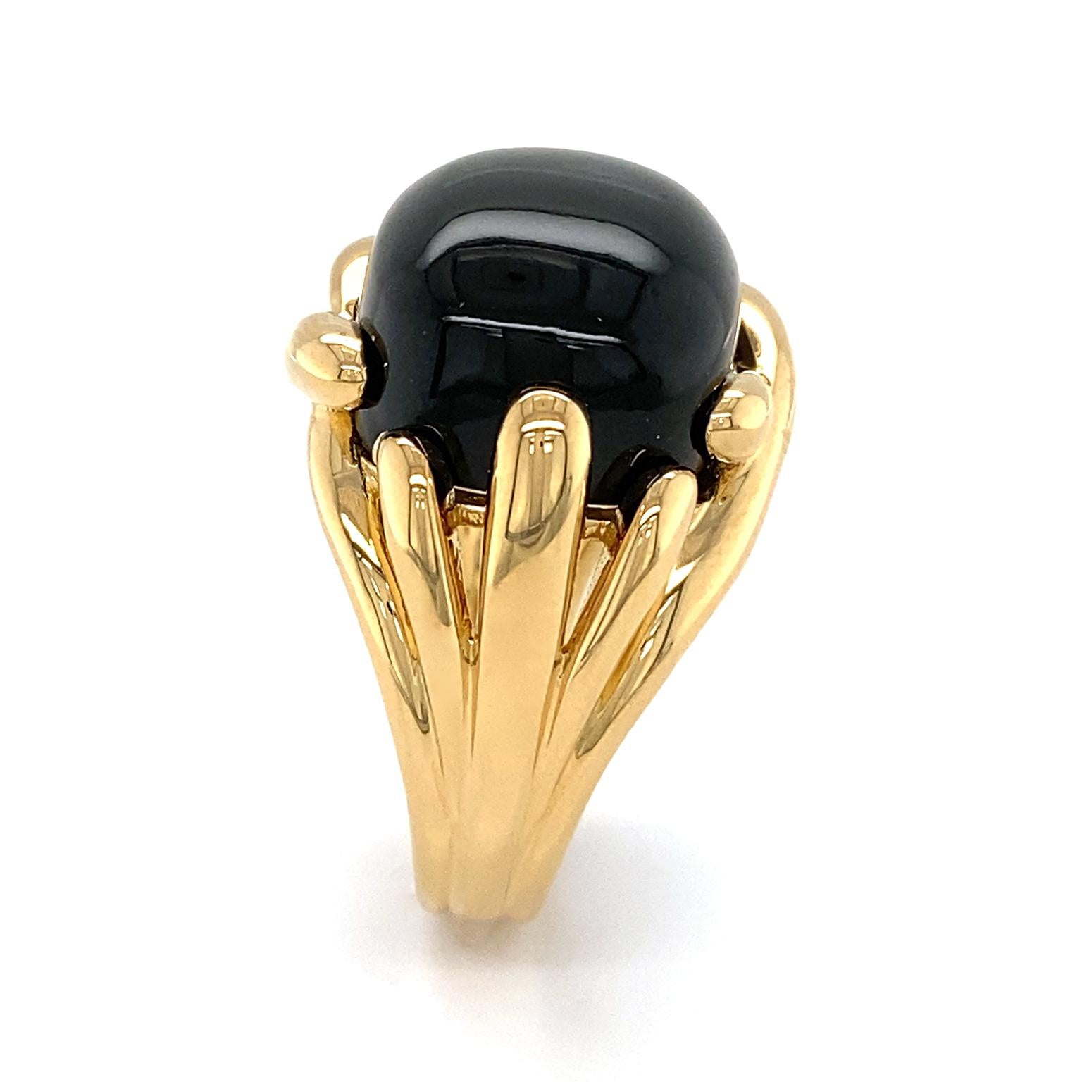 The striking opacity of black onyx is the summit of this ring. A cushion cabochon of the gem is further underlined by polished 18k yellow gold. Fluted tips of the metal overlap to surround the gem and descend into a multi-split shank. The total