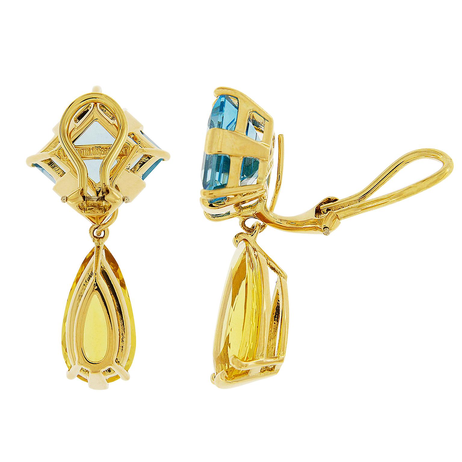 Blue and gold make these bright drop earrings. The base is made of square-shaped blue topaz, set at an angle in 18k yellow gold. Underneath is an elongated pear-shaped citrine. A delicate gold ball rests between the gemstones. These earrings are
