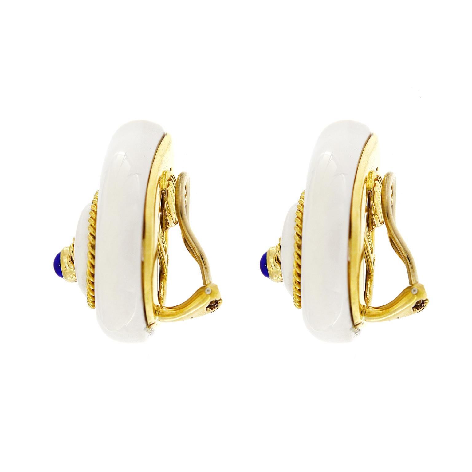 Gemstones illustrate a polished snail shell. Cacholong is carved in an asymmetrical teardrop shape as the base. An 18k yellow gold braid rotates in a coil for definition of the shell, while drawing the eye to a lapis lazuli in the center for a