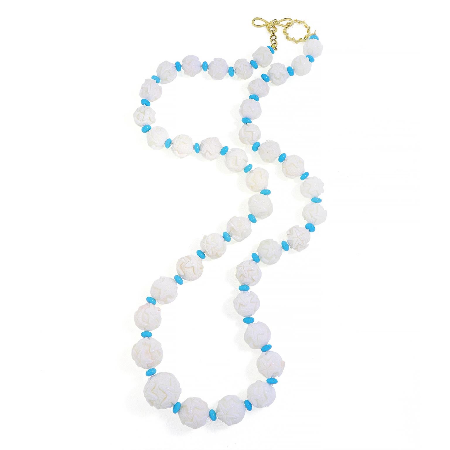 An aquatic ambiance is evoked by this necklace. Graduated orbs of white coral are carved with a starfish emblem. In between each orb is a single turquoise rondelle, which gives a breath of serene color. An 18k yellow knot and toggle close the