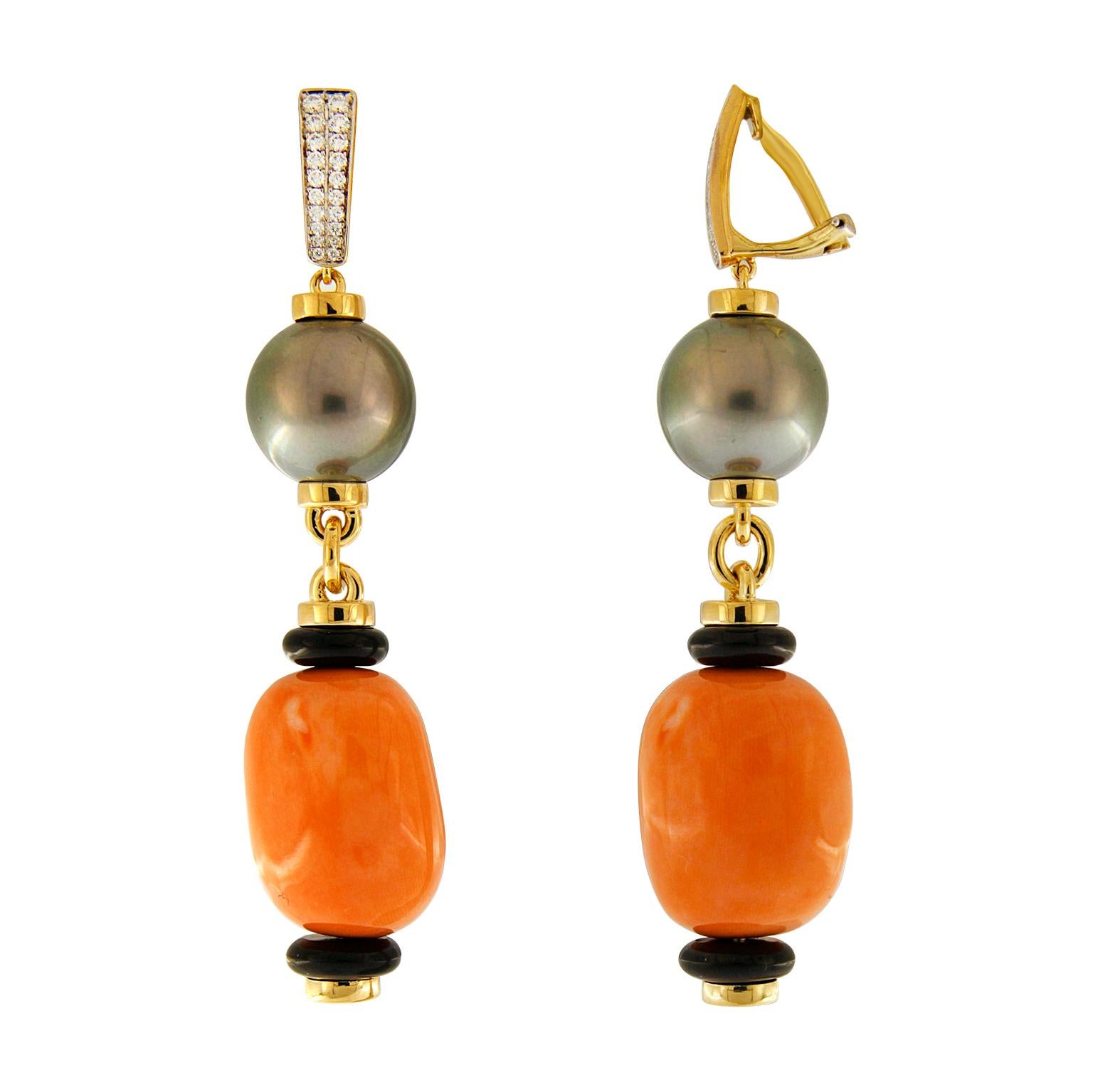 The sea inspired these drop earrings. Each piece boasts a Tahitian pearl hanging from a round brilliant cut diamond base. Roundels in 18k yellow gold sit above and below the pearls, coordinating with the jewels' iridescence. The bottom of the