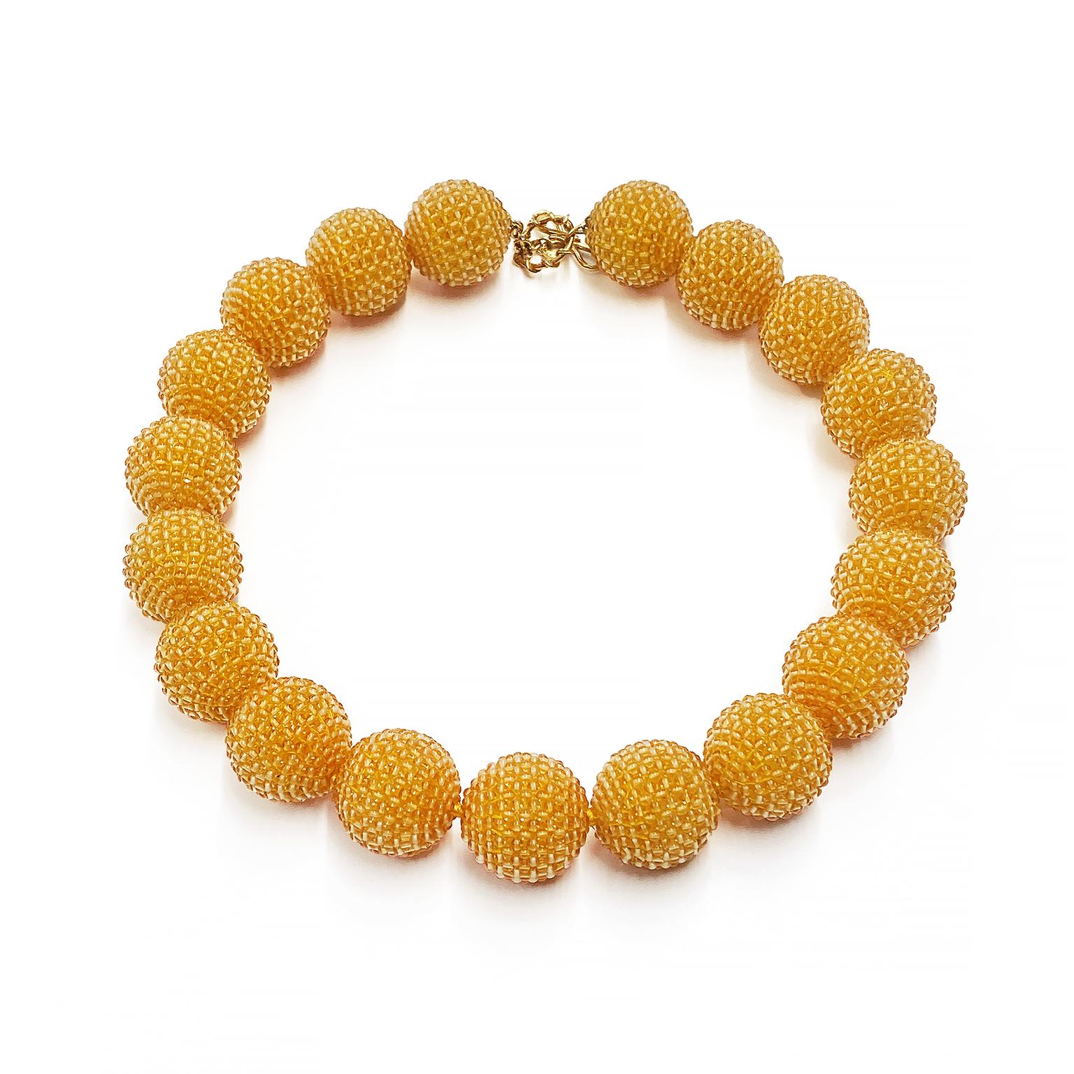 Hand selected citrine beads create both an elaborate and elegant touch to this necklace. Citrine beads in patterns of parallel stripes and checkerboard in the center, are woven on orbs measuring 25mm in diameter. Strung on a single strand, an 18k