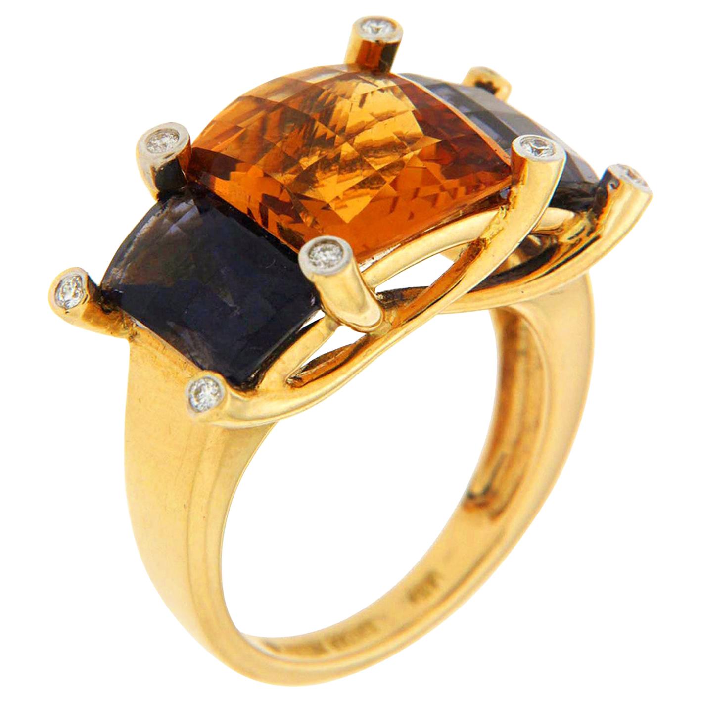 Valentin Magro Colori Citrine Iolite Diamond Gold Three-Stone Ring star secondary colors. Its central jewel is a Madeira citrine with a checkerboard surface. On either side are rectangular iolites. The gems rest in an 18k yellow gold band with