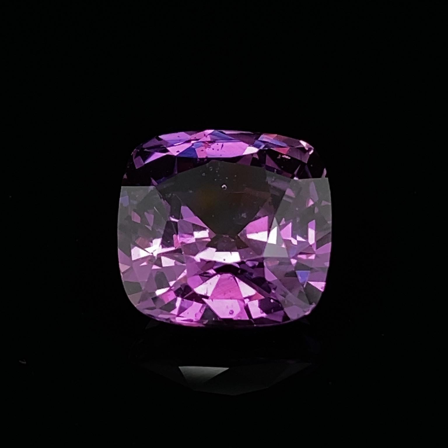 Valentin Magro Cushion Cut Purple Sapphire boasts strong colors. Its hue is reddish purple with medium dark tones underscoring its appearance. The saturation, or intensity, is vivid, making the stone an eye-catching jewel. Clarity characteristics,