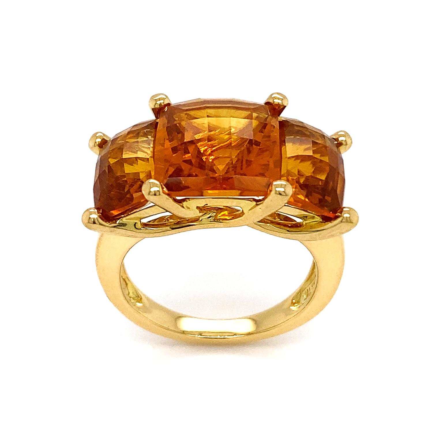 The flaming amber light of madeira citrine is the crown of this ring. Three cushion cuts of the gemstone are arranged with the center elevated above the other two. 18k yellow gold serves as the band and secures each gem as the prongs intertwine in a
