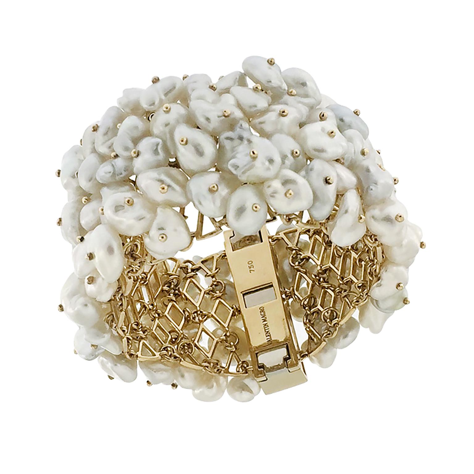 Valentin Magro Dangling White Keshi Pearl Bracelet is made of glossy hues. The 18k yellow gold body supports dozens of keshi pearls. These jewels are known for their irregular shapes and high amounts of nacre. Their play of light and shadow is