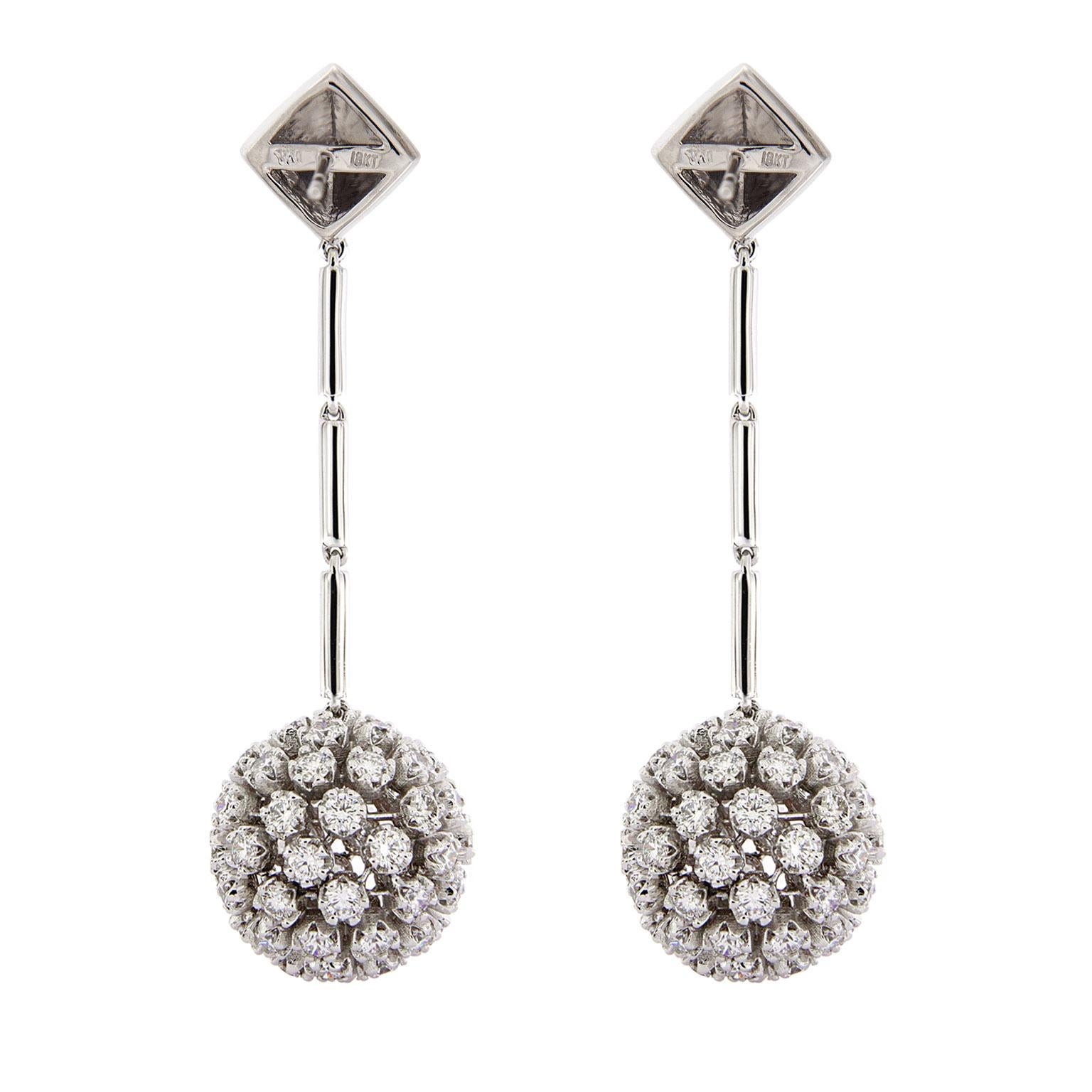 These earrings play with monochrome. Their base is 18kt white gold, with round brilliant cut diamonds for glitter. At the top are pyramids, at the bottom are diamond balls and gold links connect the two. There are 122 diamonds at 8.71 ctw. 