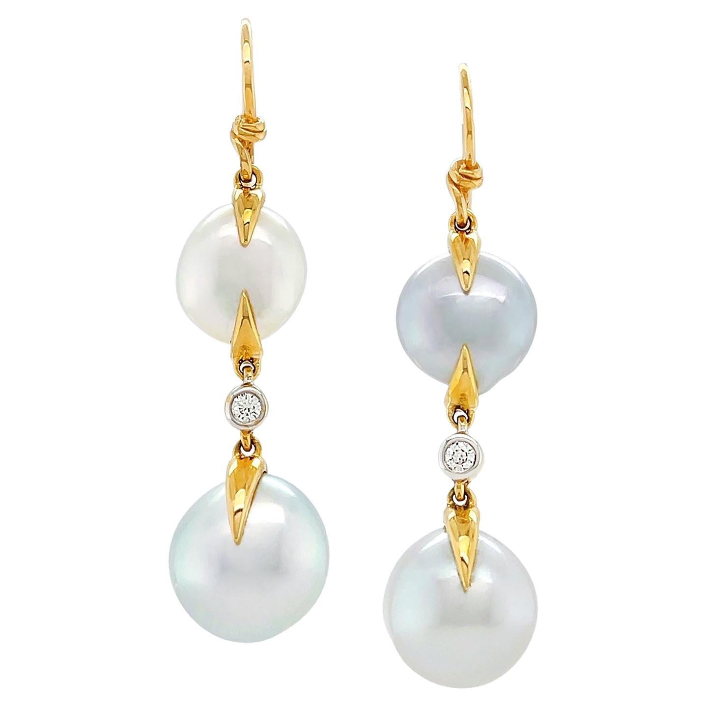 The elegance of the keshi pearl is combined with gold. 18k yellow gold knots suspend two keshi pearls in a disk shape with baroque texture. The pearls produce a satin texture as the light falls on them. In between a bezel set brilliant cut diamond