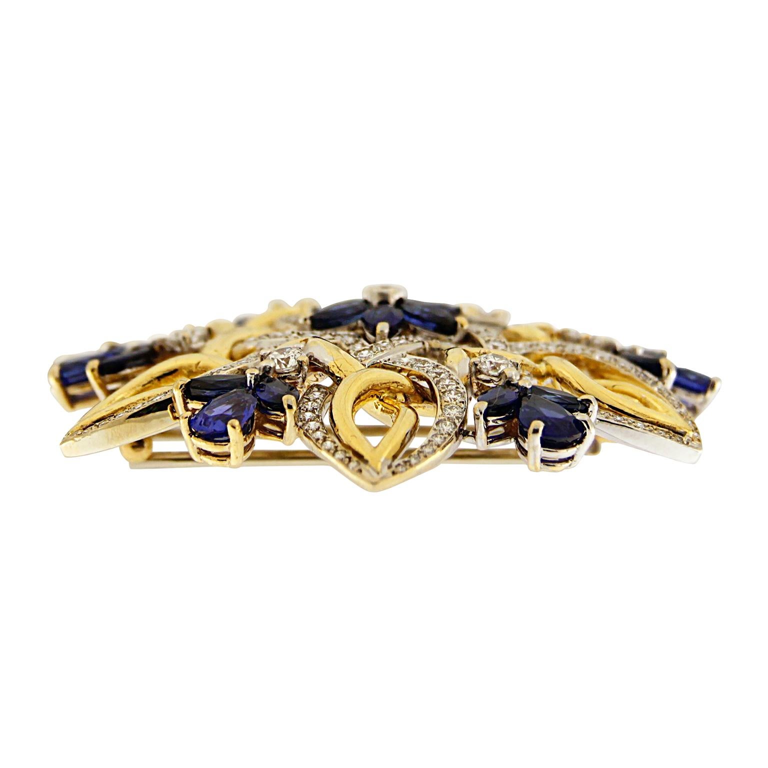 An ornamented pattern is created as two strands, one of gold and another of pavé set diamonds, intercrossed. At the heart of this design are marquise sapphires forming the silhouette of a flower as a brilliant cut diamond rests in the middle. Trios