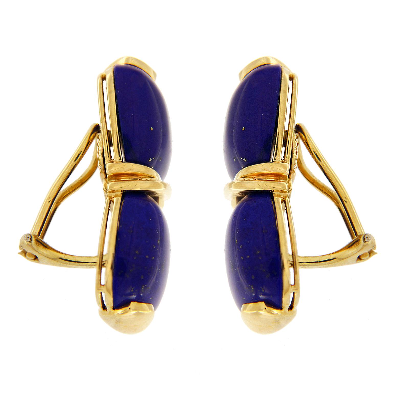 Valentin Magro Double Lapis Cushion Cabochon Earrings are adorned in blue and gold. The bodies are lapis lazuli carved into cushion shaped cabochons. These are mounted two to an earring, with an 18k yellow gold crisscross in between. This gives the