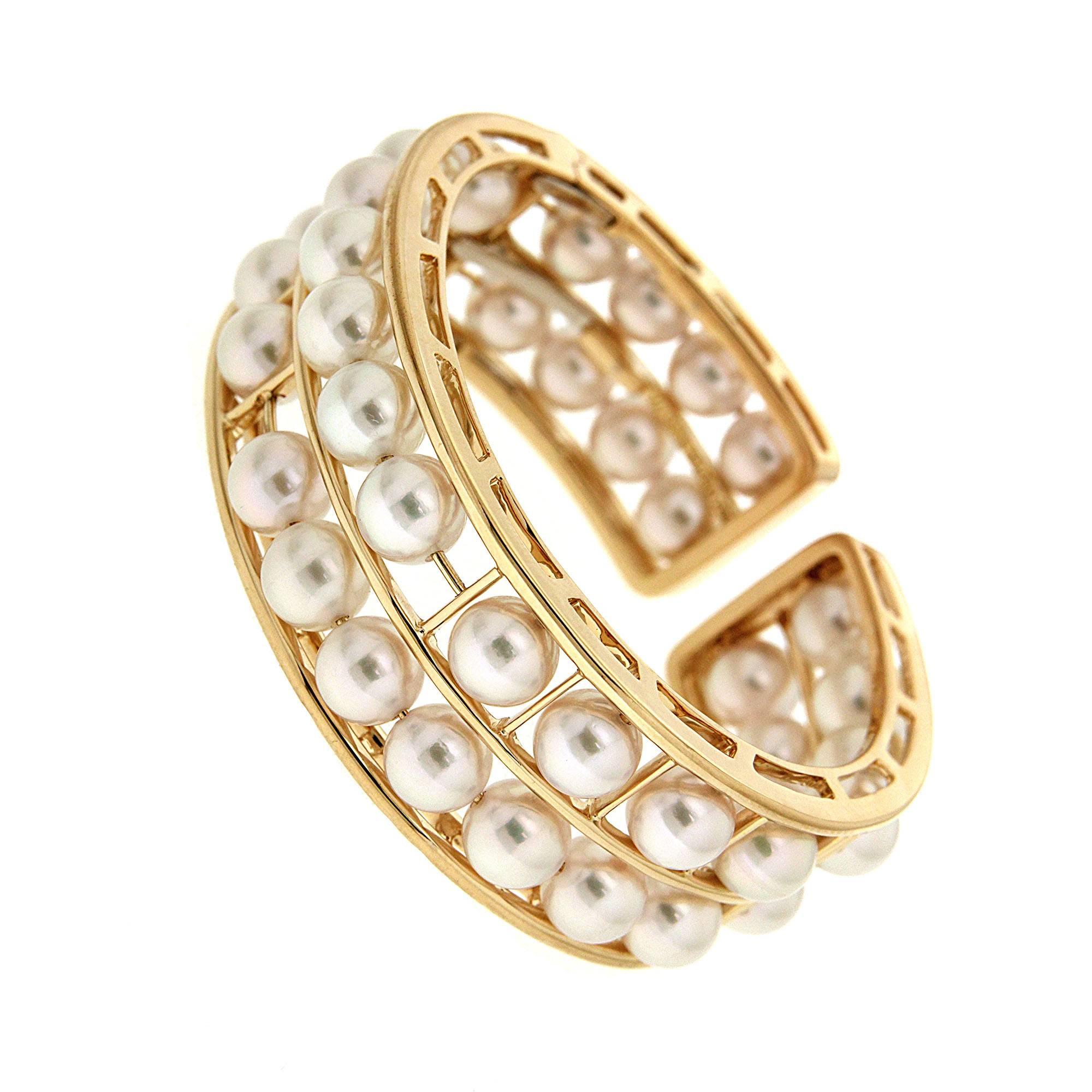 This cuff bracelet created by Valentin Magro is filled with pearls. The frame is 18k yellow gold divided into two rows. Between them shine round white Akoya pearls. At first glance, the jewels seem to float in place. Gold wires running through the