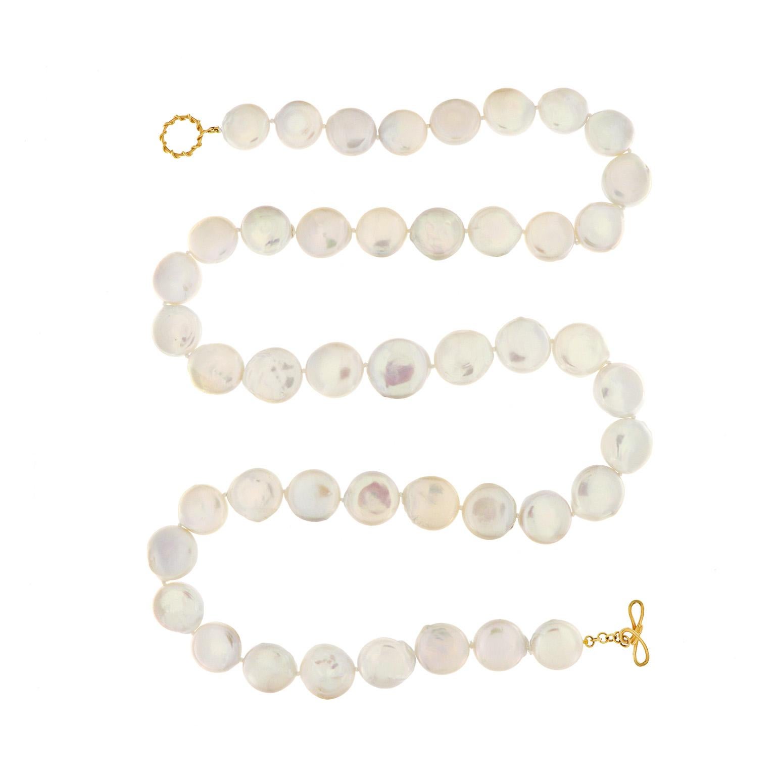 Soft iris hues demonstrate the beauty found from the freshwater pearls in this necklace. Carved into coins, the pearls reflect delicate colors as the light falls upon them. The total weight of the 20mm round pearls is 45 carats. An 18k yellow gold