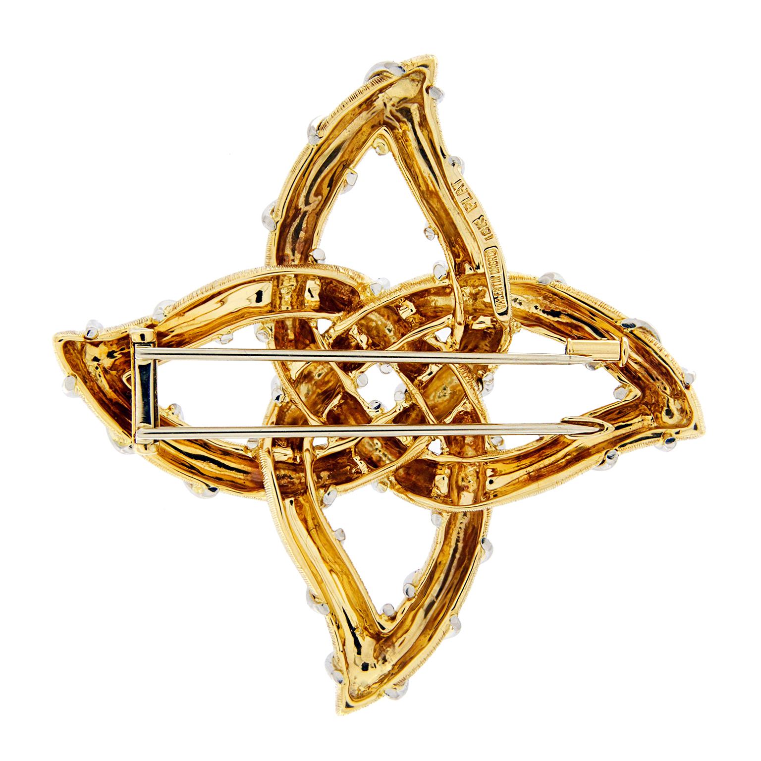 This Valentin Magro Brooch is crafted with 18kt yellow gold textured finish and platinum wire, it is a mix of twin metals designed into a Gothic pictogram. The gold framework reveals four petals attached to a semi-circular pod at the center. The