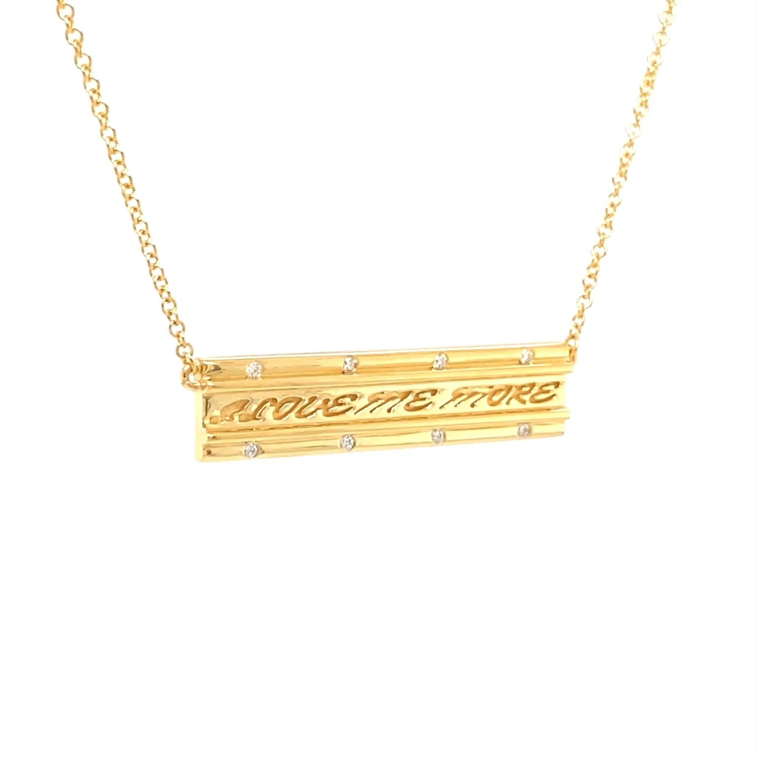 Diamonds highlight this pendant’s message. The body is made of 18k yellow gold shaped into an elongated bar. Wires edge the shape, while an engraved 'I love me more' fills the center. Round brilliant cut diamonds embedded in the gold add flashes of