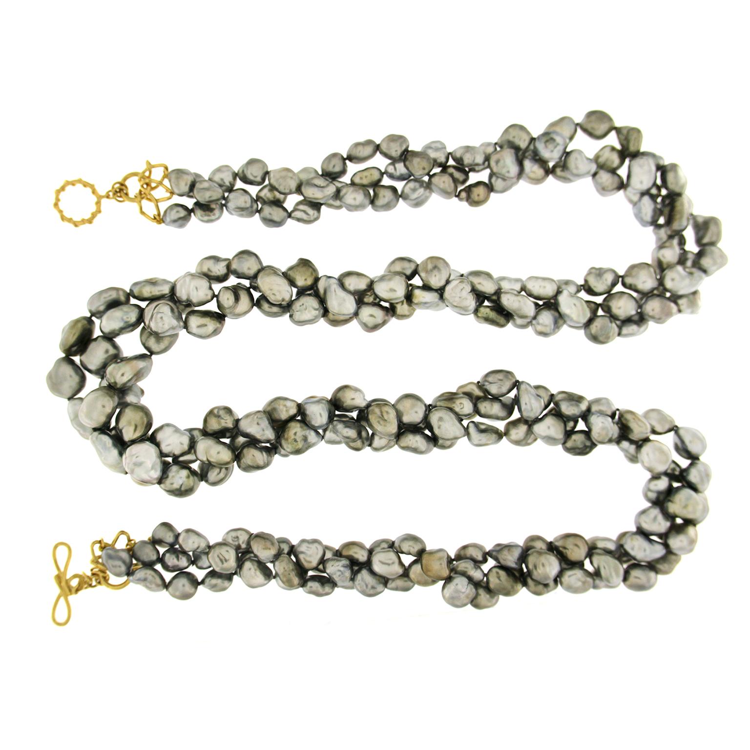 Valentin Magro Keshi Pearl Three-Strand Necklace is a study in shape. The jewel of choice is grey keshi pearls. These gems boast irregular baroque shapes with pure nacre bodies, giving them unique luster which gleams every which way. The pearls are