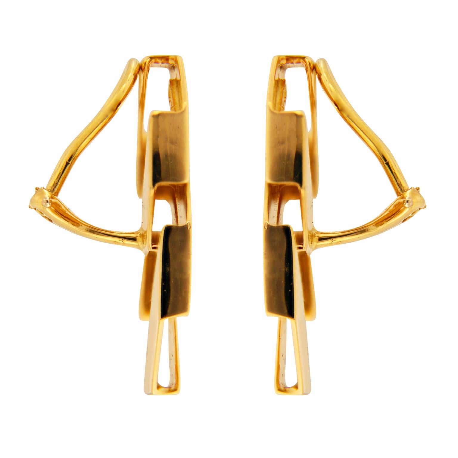 Valentin Magro Large and Small Double Fold Over Link Earrings play with form. The upper piece resembles a loop folded into a flat octagon. Its lowest side links with its larger cousin, another folded shape. Both pieces feature a satiny finish. These