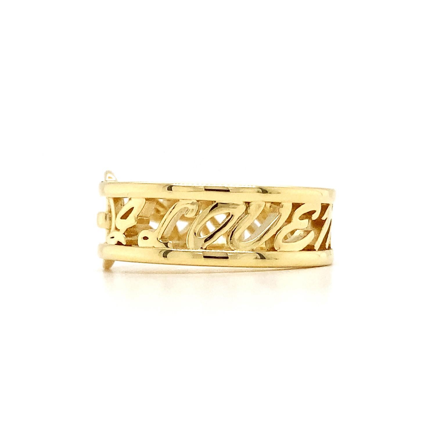 Several touches make this ring stand out. One is a buckle, complete with a bar, prong, and oval frame. The words 'I love me more' span the rest of the band, with cursive letters traveling between thin shanks. Taken together, the buckle turns the