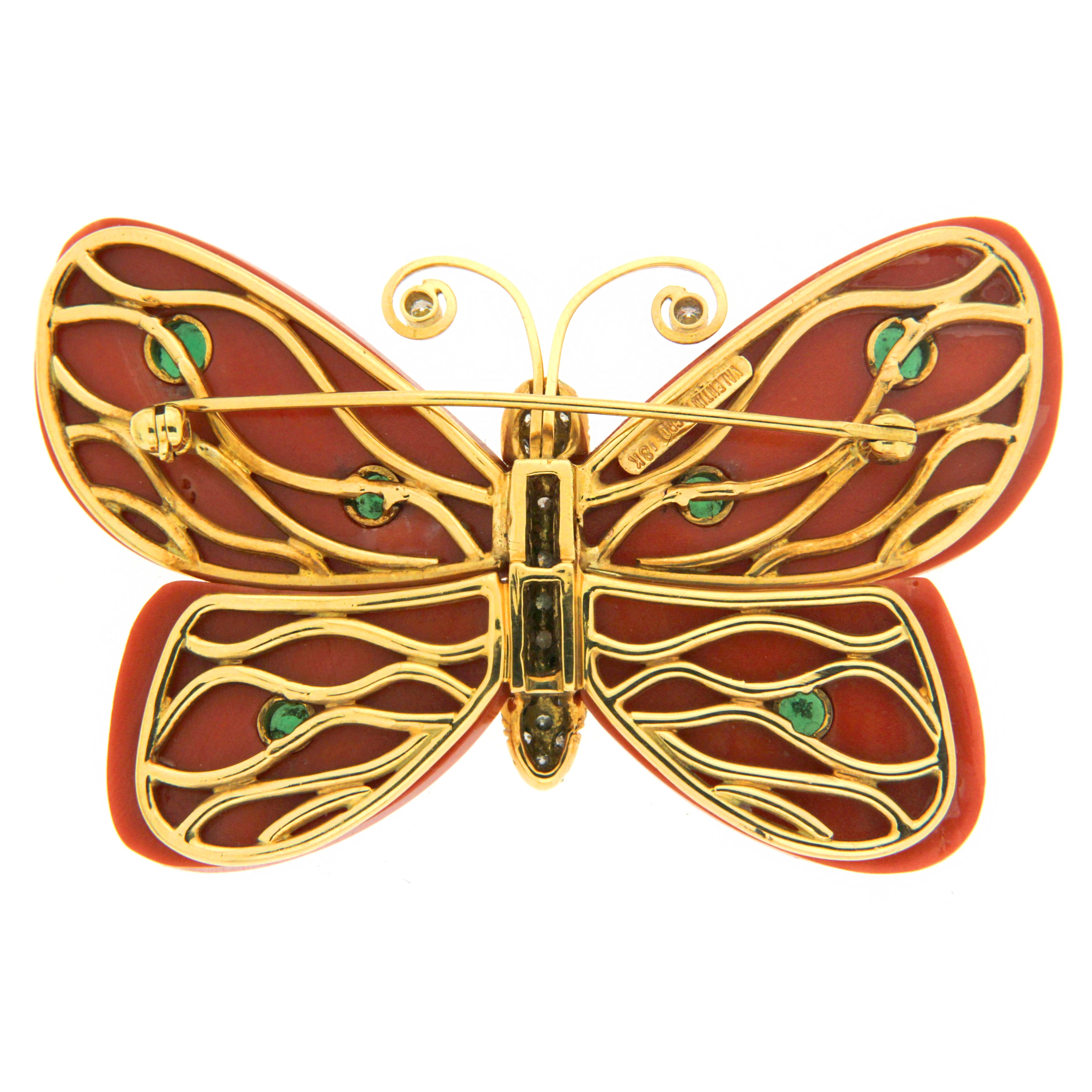 Gems envision a butterfly for this whimsical brooch. 18k yellow gold is the base, as brilliant cut diamonds embellish the body. Golden wire curls for the antennas, accented by a single diamond on the tips. Four special cuts of coral serve as the