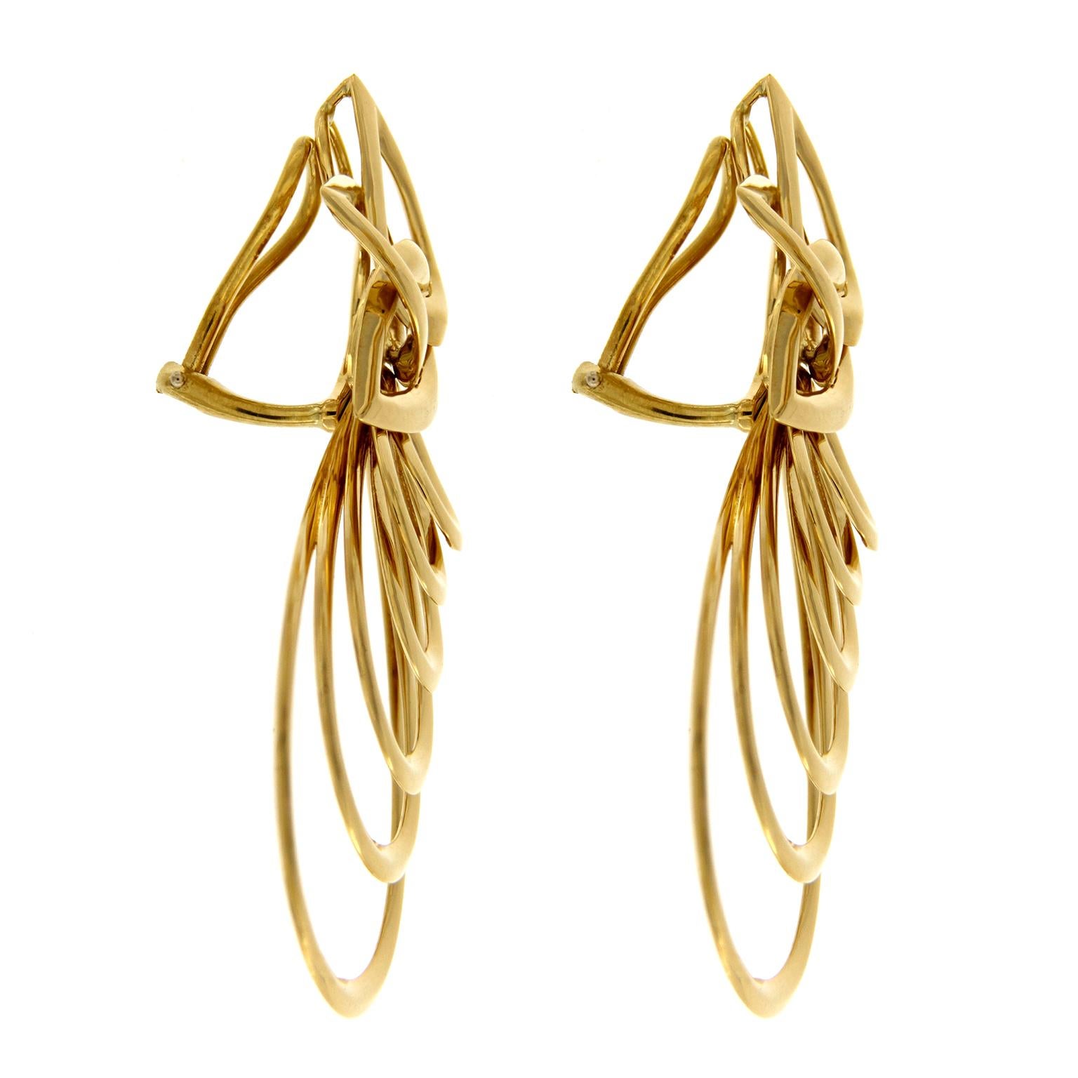 Le pere traforate formano questi orecchini a goccia. Sopra, tre pezzi in oro giallo 18k si incastrano alla base e si aprono a ventaglio sulle punte. Sostengono una serie di pere pendenti, una dentro l'altra. Ogni cosa mostra uno smalto brillante. I