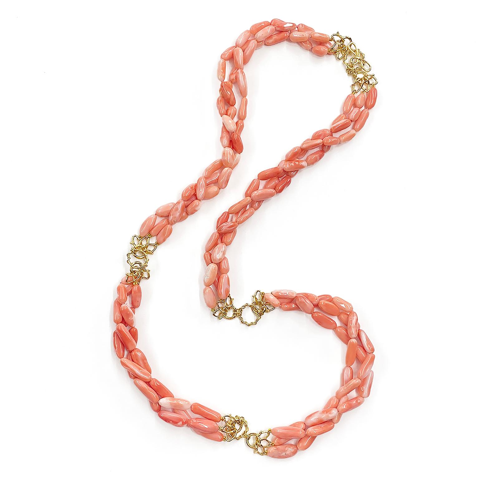 The elegance of angel skin coral is illustrated in three strands of carved nuggets. Three 18k yellow gold Vs connect to round rings throughout the necklace. The total weight of the corals are 882 carats. A knot and toggle clasp secures the necklace,