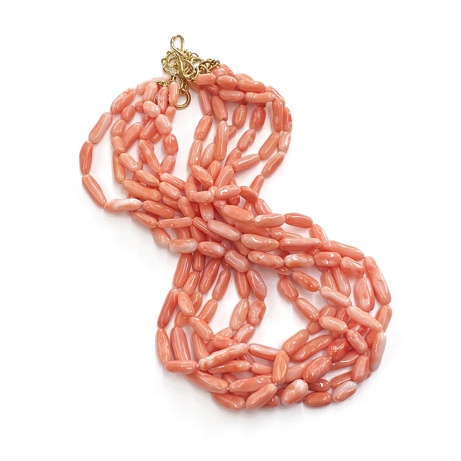 Die zarte Schönheit der Engelshaut wird in dieser mehrreihigen Halskette gewürdigt. Die Koralle ist in unregelmäßig geformte Nuggets gehauen und auf insgesamt sechs Stränge verteilt. Dies ermöglicht es, die Untertöne einer Reihe von rosa