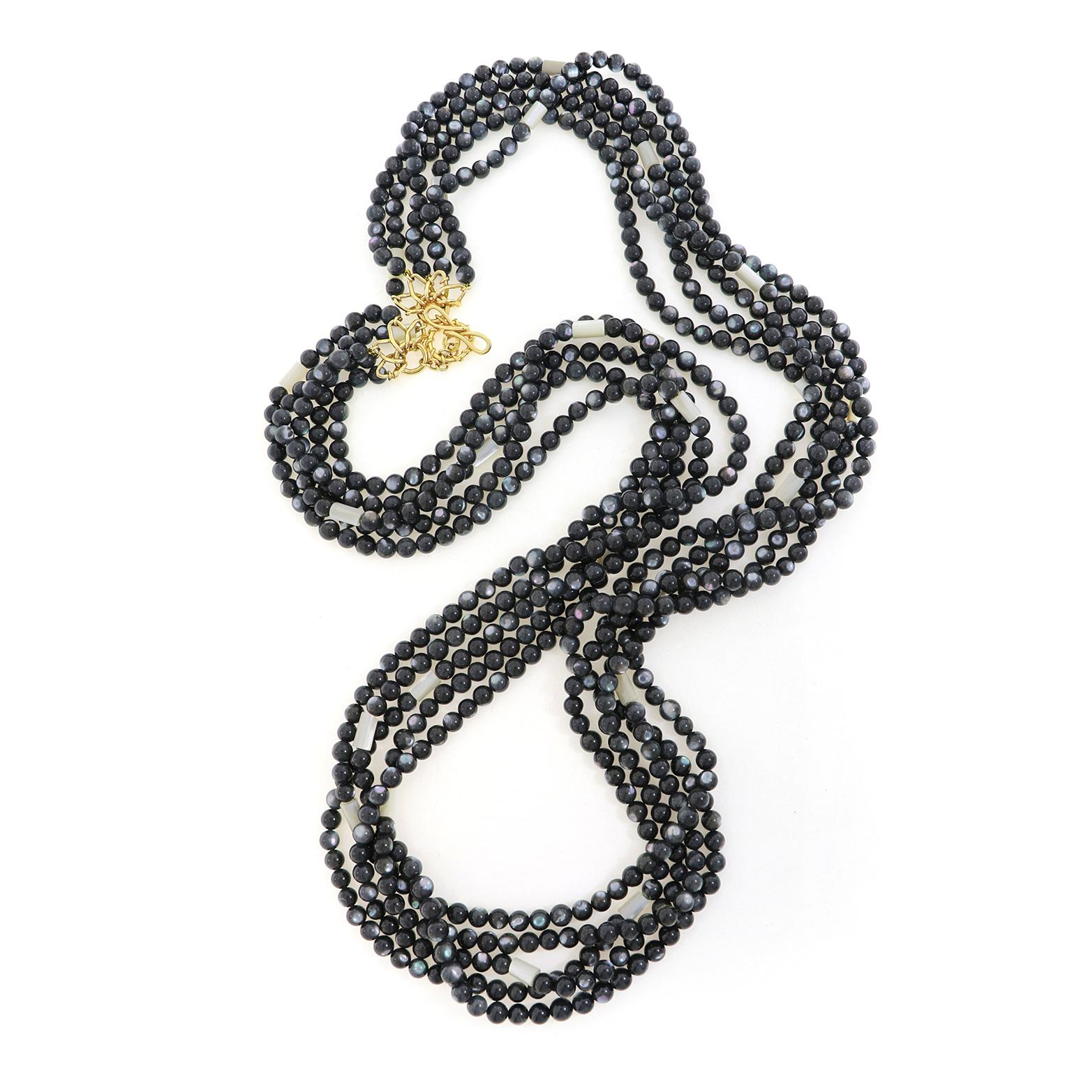 Beads of black mother of pearl glimmer varied colors in this five strand necklace, accented by white mother of pearl and secured by 18k yellow gold. Round beads of black mother of pearl are strung on coordinating thread, while narrow tubes of mother