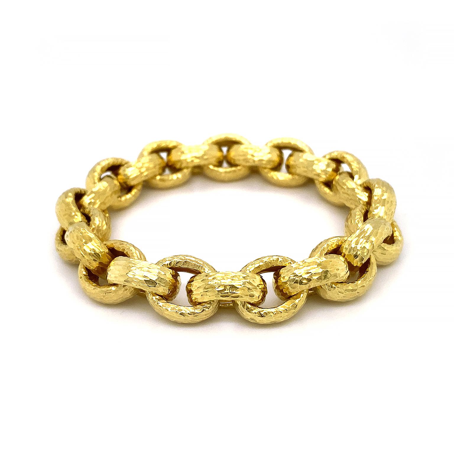 Ovals made of 18k yellow gold connect together. Throughout the bracelet is a hammer texture, which creates a patina for a classical flair. A hidden clasp secures the bracelet, which measures 0.52 inches (width) by 7.88 inches (length).