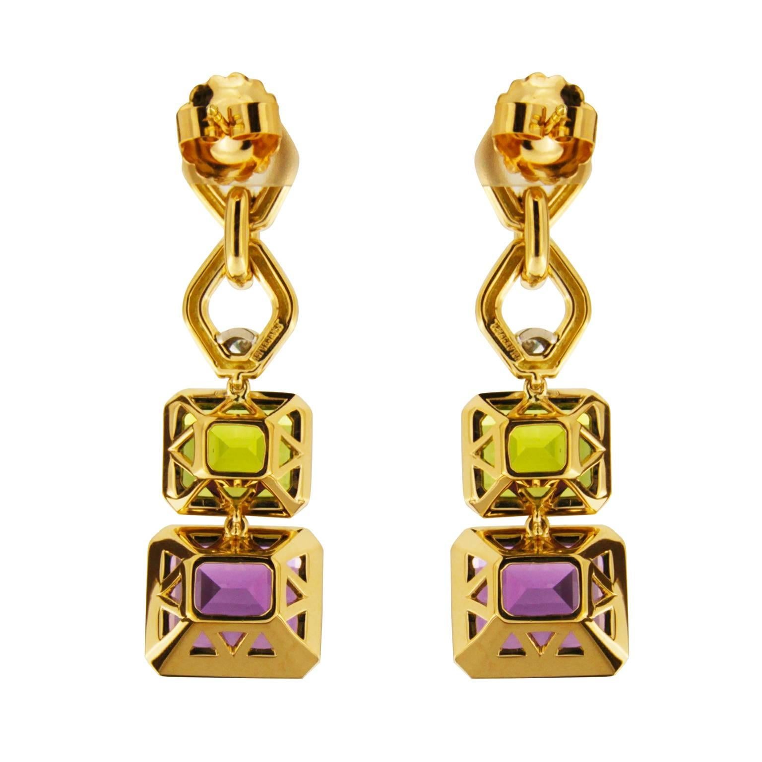 These 18k yellow gold and platinum drop earrings boast a range of gemstones. Amethyst topped with peridot hang from the bottom. Above are rhombus shaped links highlighted with round brilliant cut diamonds. There are two emerald-cut amethysts in all.