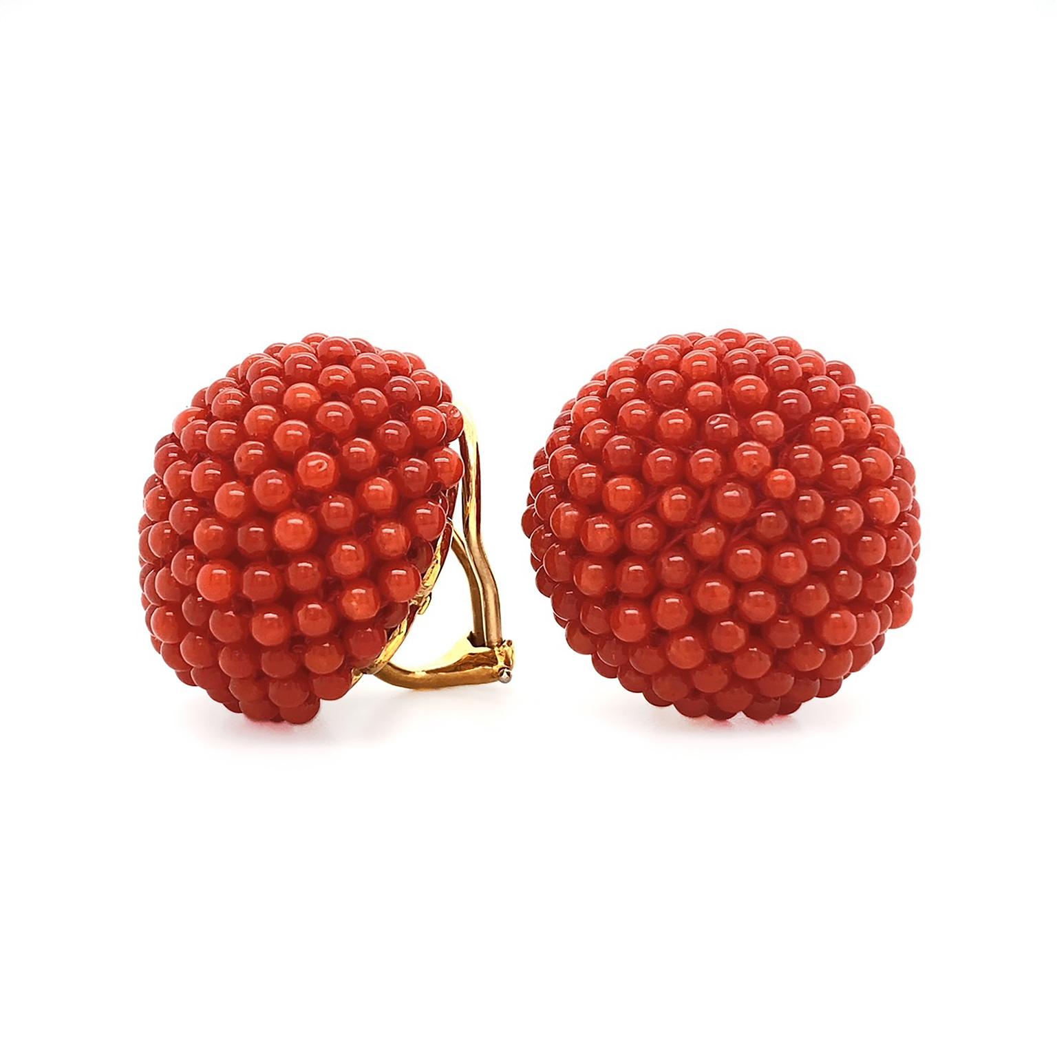 The remarkable vivid hue of red coral is featured in these earrings. The gemstone is carved into miniature round beads and arranged close together for a detailed and textured pattern. The total weight of the red coral is 14.8 carats. 18k yellow gold