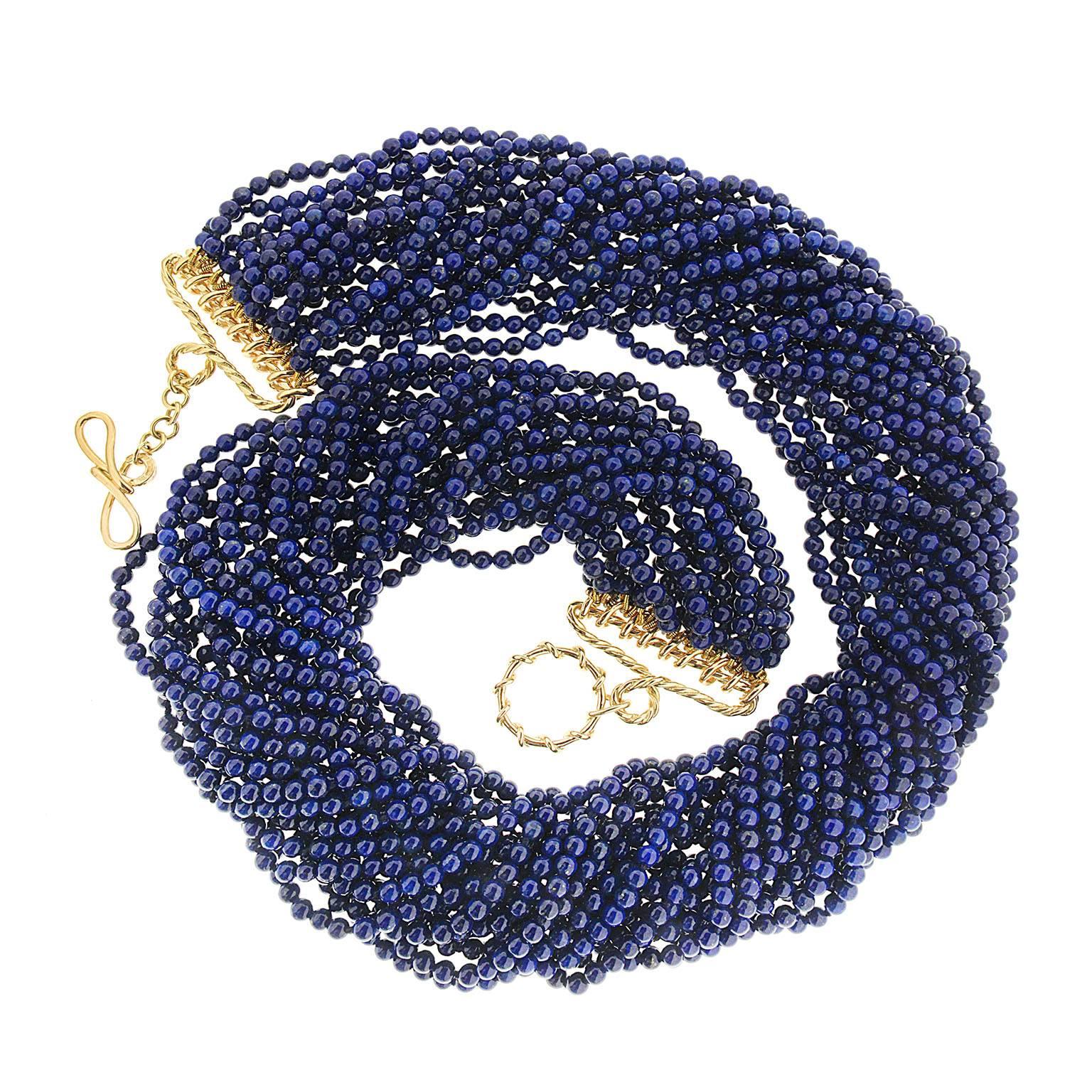 Valentin Magro Round Lapis Lazuli Multi Strands Necklace overflows with blue. The showcase gem is lapis lazuli, carved into countless 3.25mm beads. Together, they fill twenty strands. These individual lines twist together to form a torsade. A knot