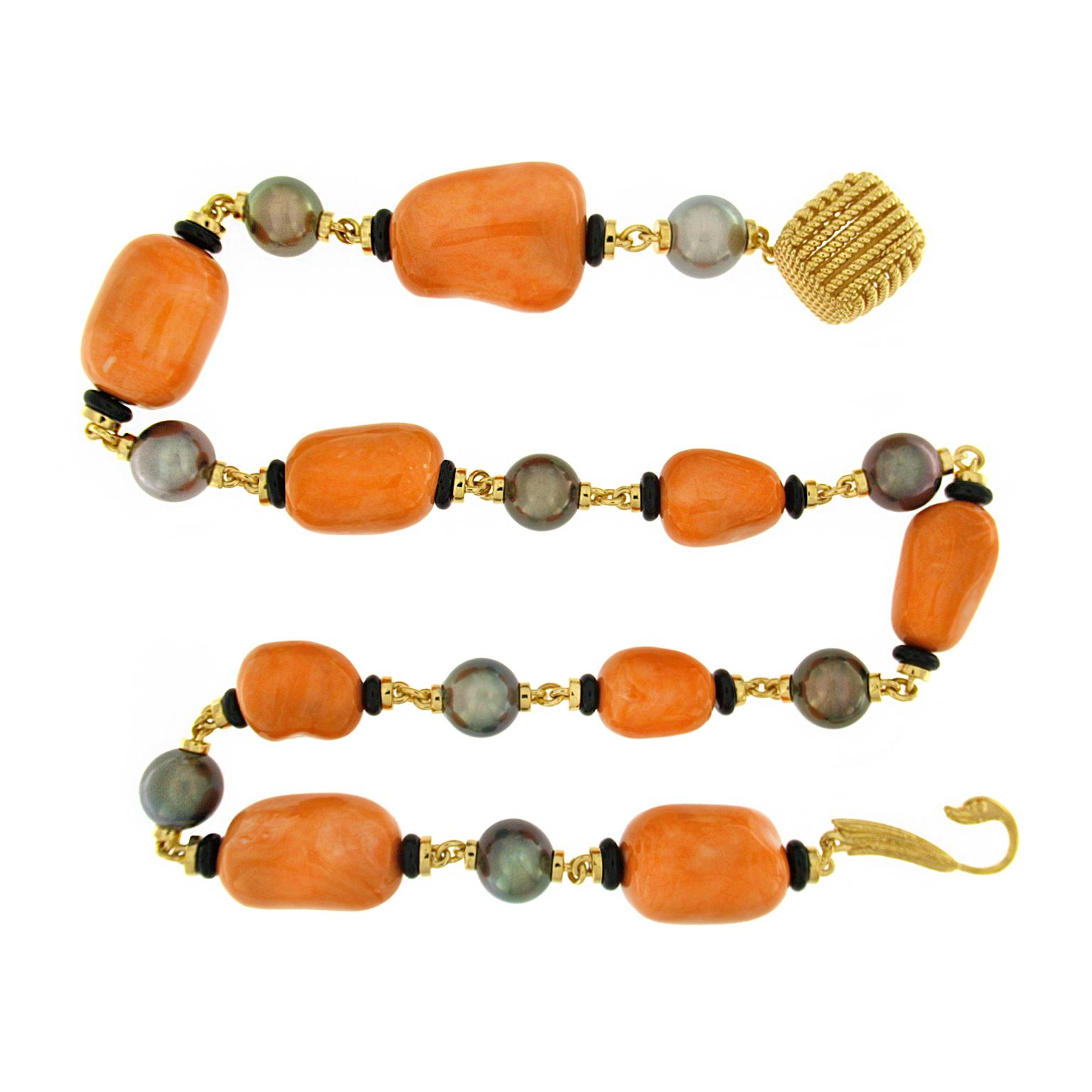 Coral and pearls join together for this necklace. Vibrant baroque shaped salmon coral is showcased, with a roundel of black jade on each side to accentuate its hue. 18k yellow gold links secure a single round gray Tahitian pearl for prismatic