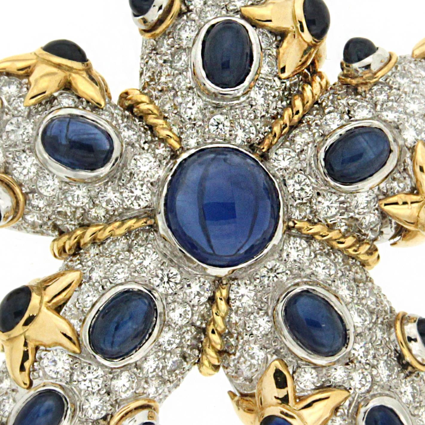 Jewels of diamonds and sapphires recreate this saltwater creature. An 18k yellow gold base is furnished with pavé set diamonds. Bezel set in 18k white gold, sapphire cabochons decorate the arms. Gold braids provide further definition of the arms and