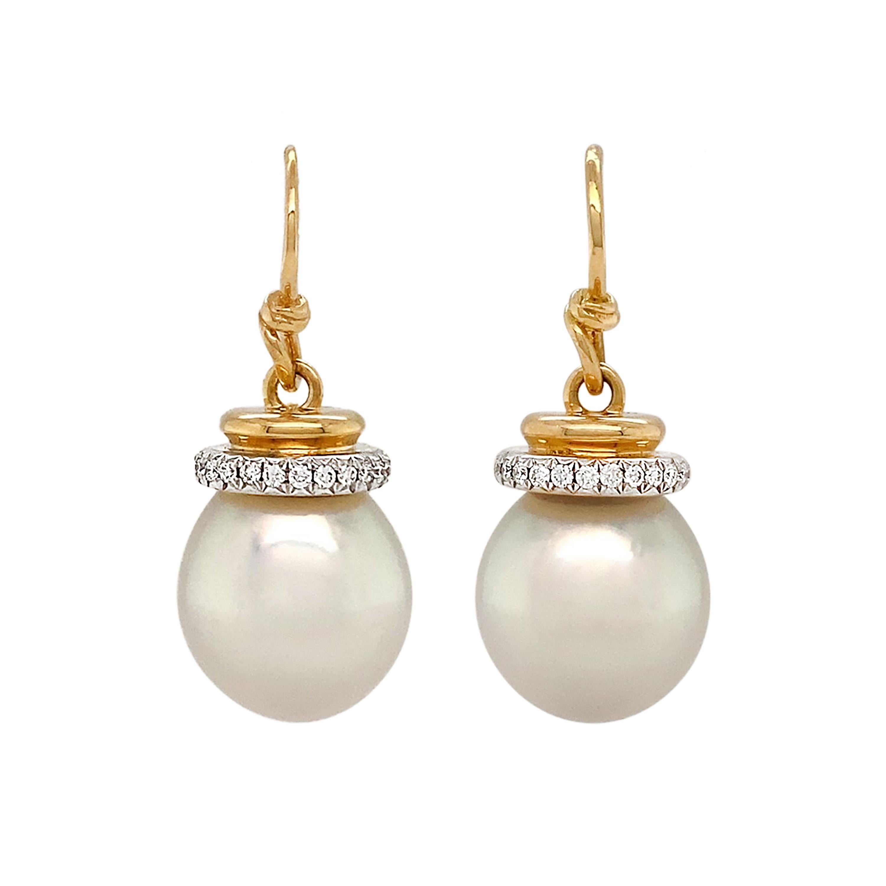 Elegance is emitted in the form of diamonds and pearls. 18k yellow gold French hooks suspend a polished gold cap trimmed with brilliant cut diamonds. The cap secures a single white south sea pearl, releasing a soft prismatic array as the light falls