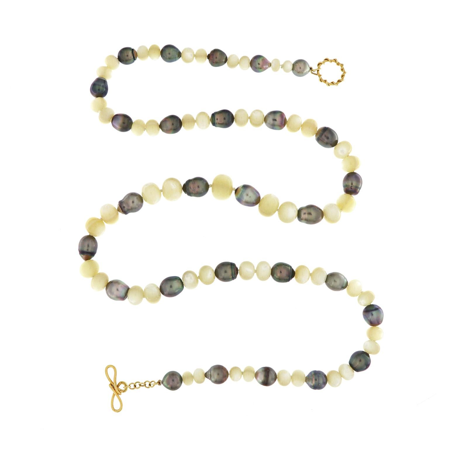 The prismatic sheen of Tahitian pearls combines with the ivory glow of mother of pearl for this necklace. In between every two-barrel shape mother of pearls is a baroque Tahitian pearl as its accent. The pearls ascend in size gradually as they move
