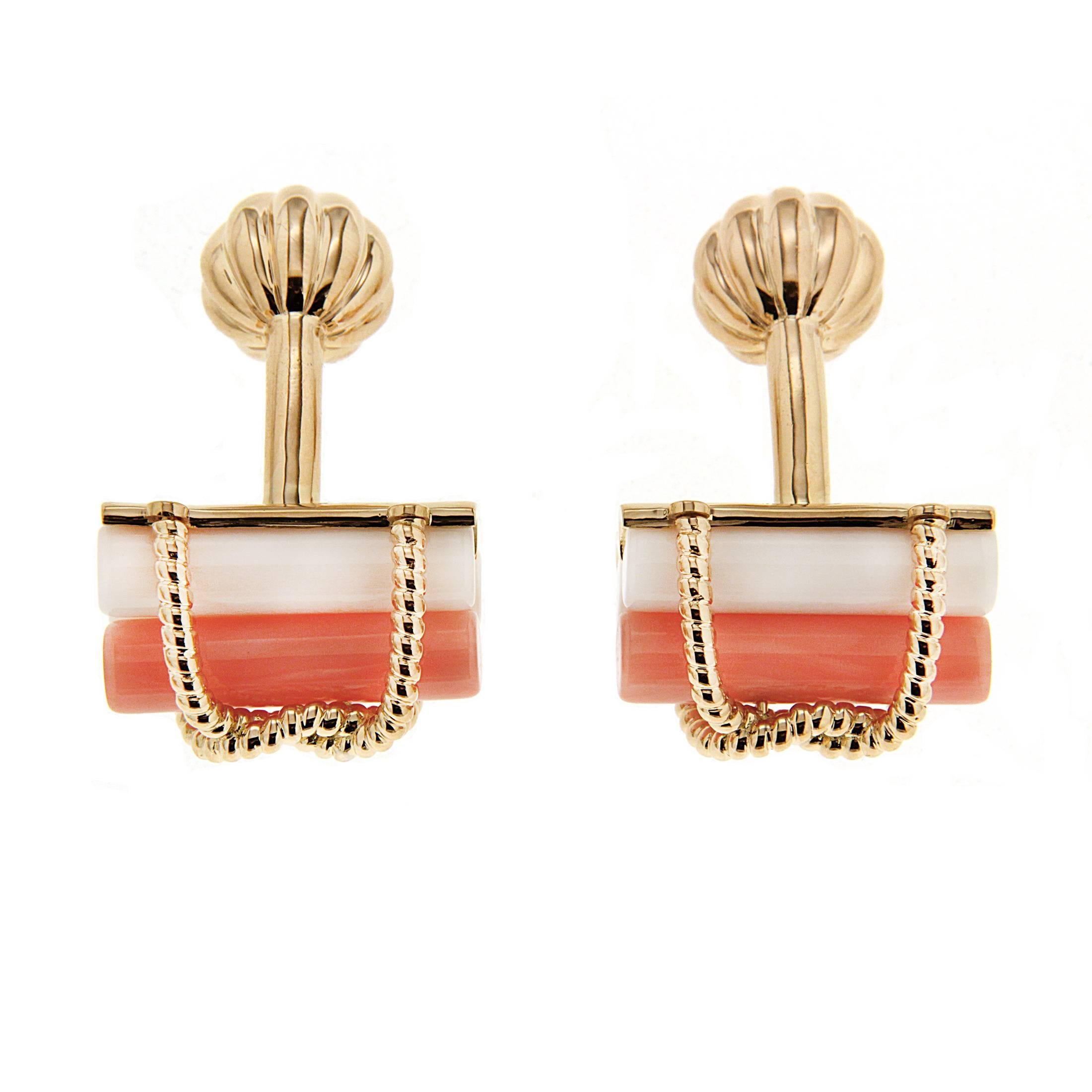 Coral and gold combine for elegant cufflinks. Tubes of the gem are the base of the motif, while intertwined 18k yellow gold braids loop over the top and bottom. The total weight of the coral is 9.25 carats. A bar and ornate ball toggle secure the