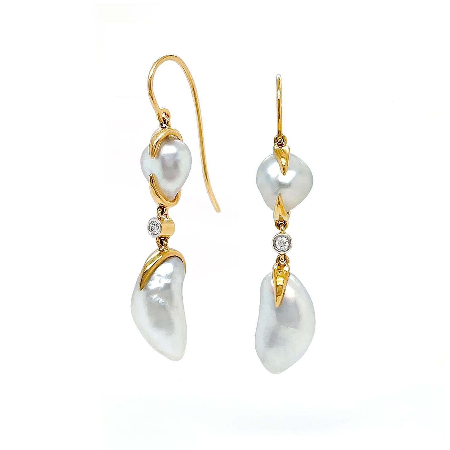 The satin bodies of white keshi pearls are the focal point of these earrings. 18k yellow gold French hooks lead to a cushion shaped white keshi pearl secured by gold. In the center a single brilliant cut diamond gives a luminous flare. Next descends