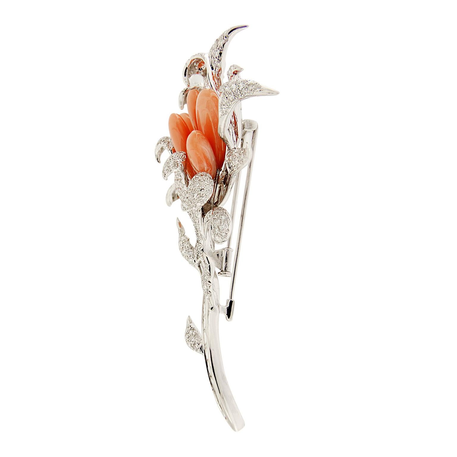 Valentin Magro Windblown Diamond and Coral Brooch seems to dance in the breeze. Pave set round brilliant cut diamonds come together to form leaves and petals. Pink coral carved into drop shapes fill in the blossom's center. Channel set baguette cut