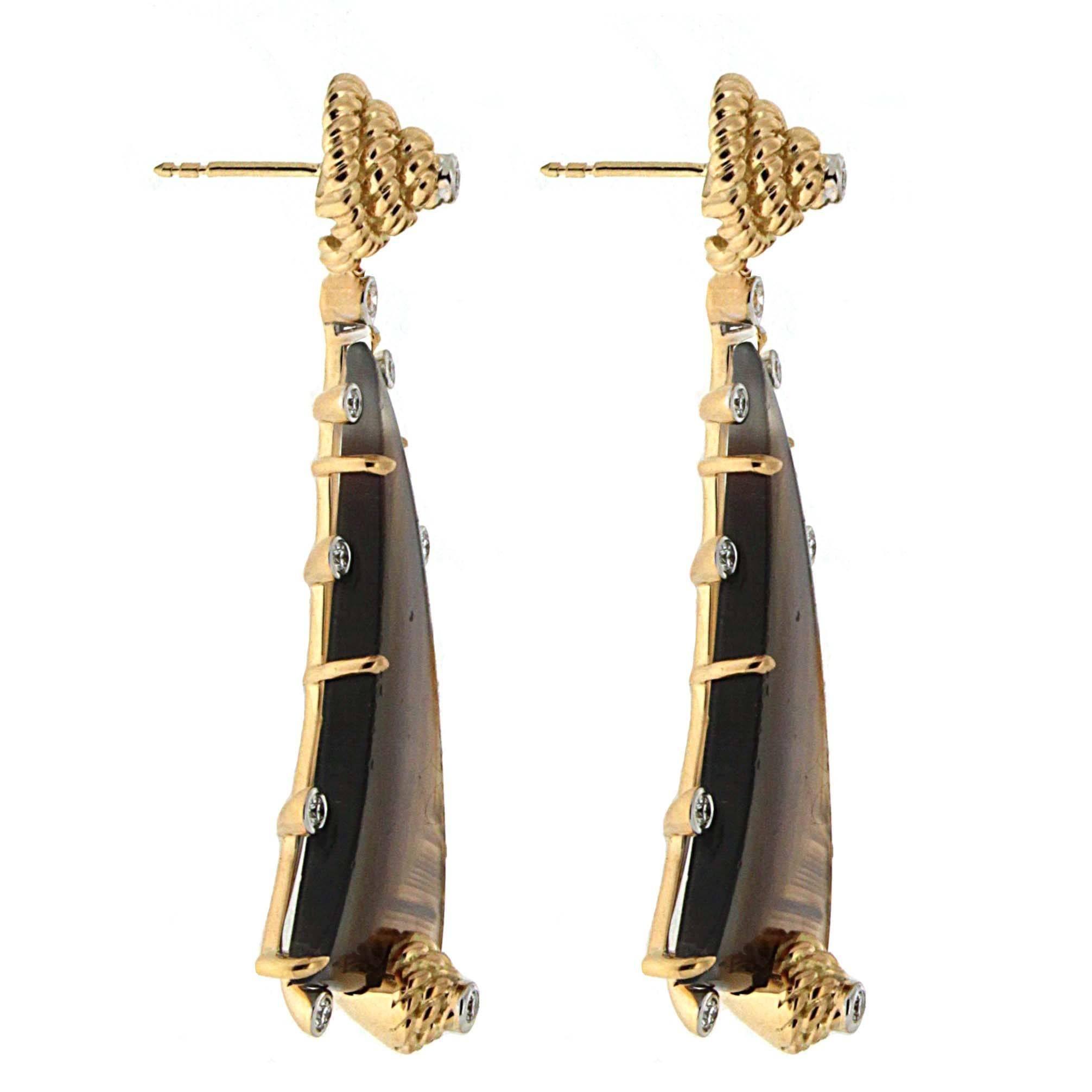 These drop earrings shimmer with warm earth tones. The design begins with an 18k yellow gold braid in a tight spiral where a brilliant cut diamond sits in the middle. Descending from this is a gold curved asymmetrical triangle, which supports a