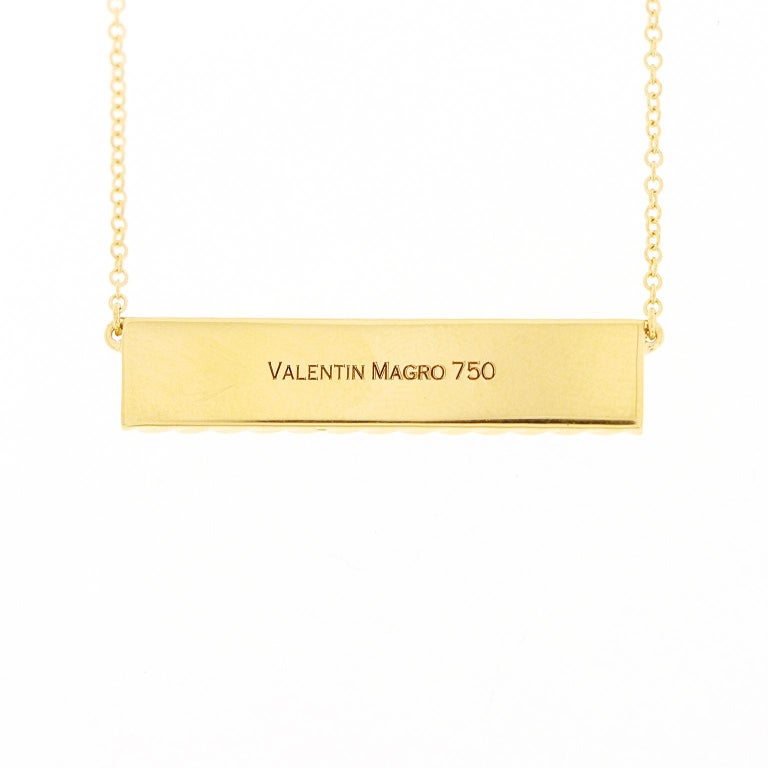 Valentin Magro Yellow Gold I Love You More Bar Pendant carries a gleaming message. The body is 18k yellow gold shaped into an elongated bar. Twisted wires placed widthwise bring texture to the design. Between them stretch the words 'I love you more'