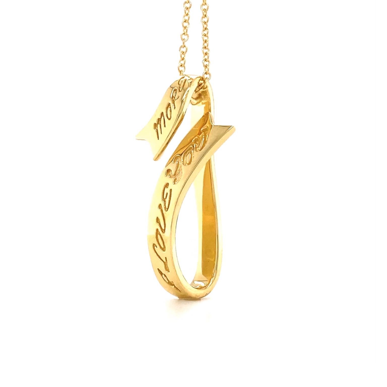 A glinting V-shaped ribbon of 18k yellow gold is the basis of this pendant. Engraved lettering features the romantic sentiment, I Love You More. One end of the ribbon is folded higher to descend from the 17-inch chain. The pendant itself measures