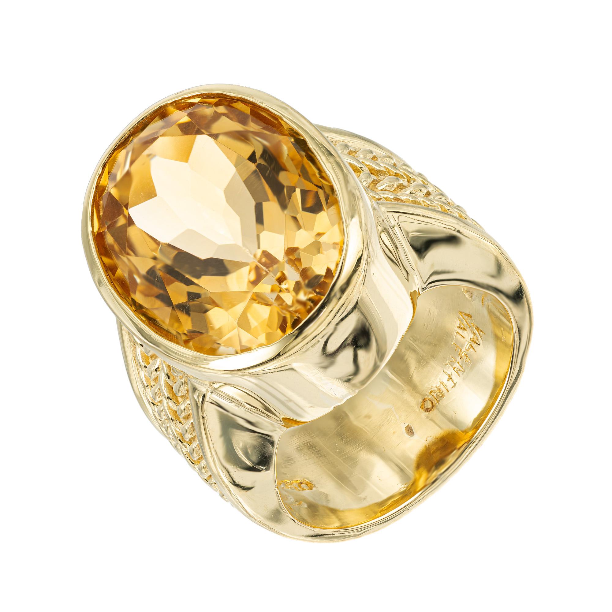 Vintage 1970's Valentino oval Citrine Yellow Gold cocktail ring. This stunning piece features a dazzling 11.00 carat oval citrine center stone, exuding a warm and inviting yellow hue. Mounted in 18k yellow gold, the setting is wide with a weave