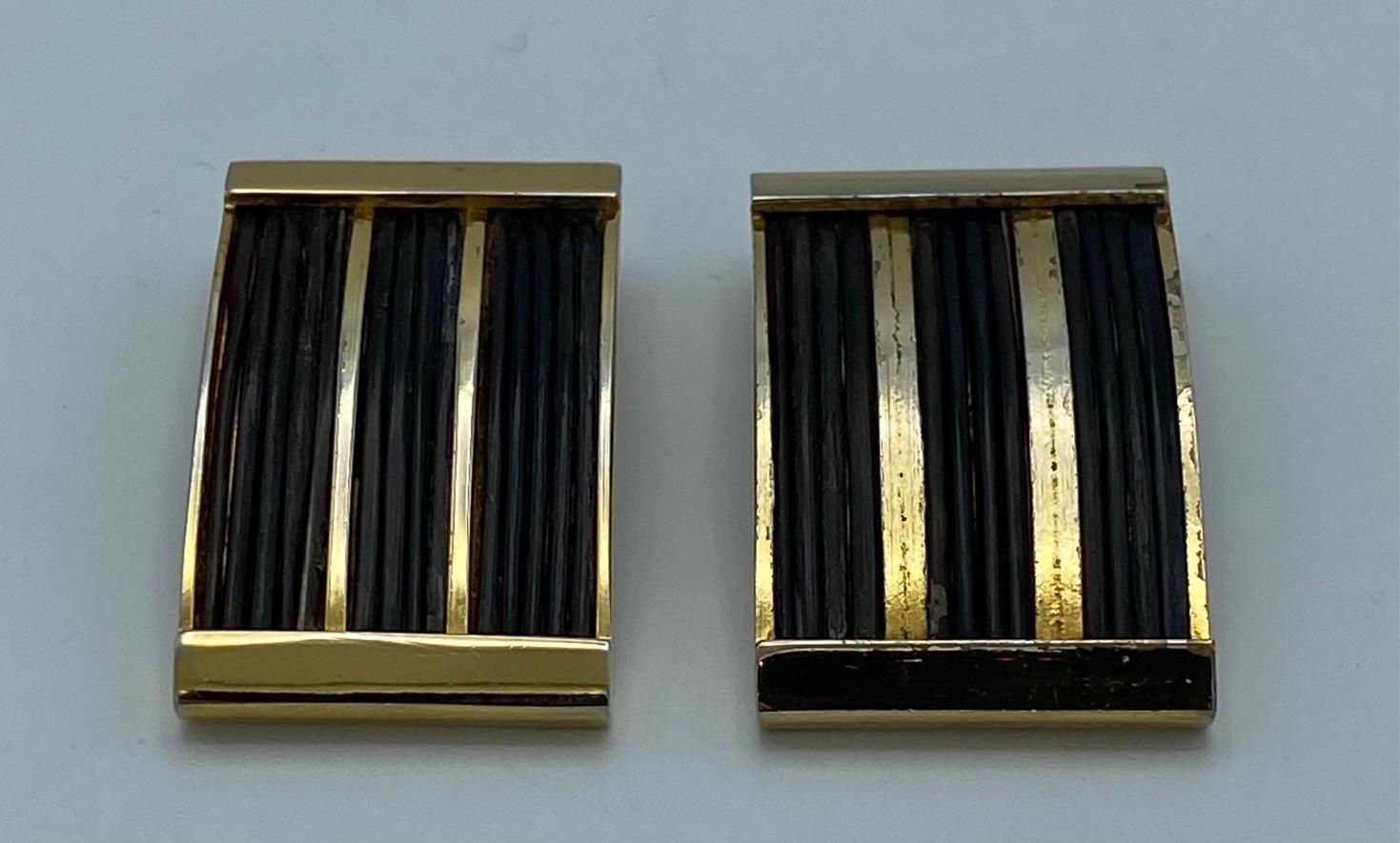 A stylish pair of early Valentino earrings from the late 1970s. Each rectangular earring is gold plate, inset with chocolate brown strands of thin cord and measures .88 of an inch wide, 1.5 inches high and .25 of an inch deep. The earring are