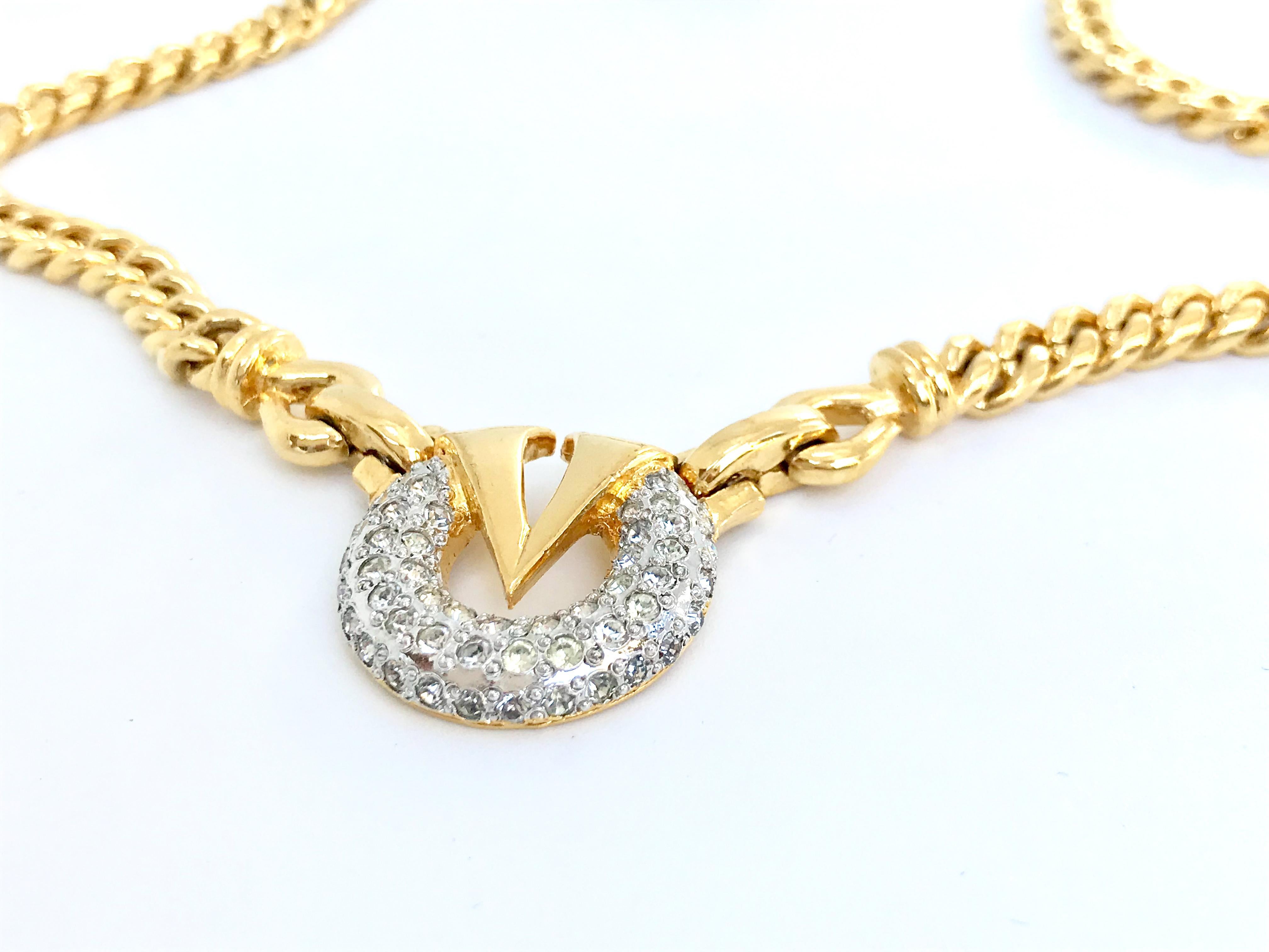 Valentino 90s vintage gold tone metal and glass crystal pendant necklace with chunky gold tone link chain. 

17 inches long and with  fold over clasp. 
Pendant diameter approx 1 inch

Features a 'V' to the centre with sparkling glass crystals.