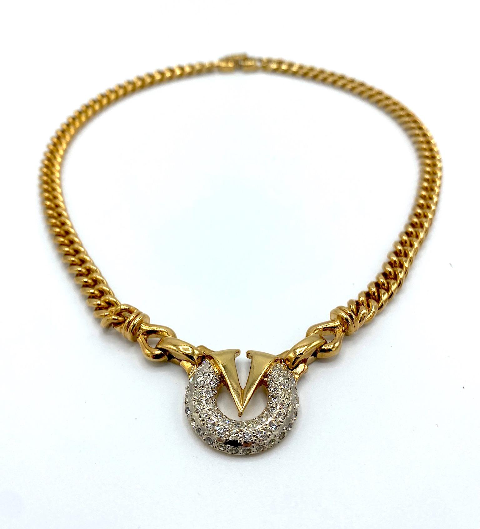 A lovely and versatile 18K gold plate necklace with rhinestone accent from the fashion house of Valentino. The curb link style chain is .25 of an inch wide. The central focal point is the gold V for Valentino inset into the pave' rhinestone set ring