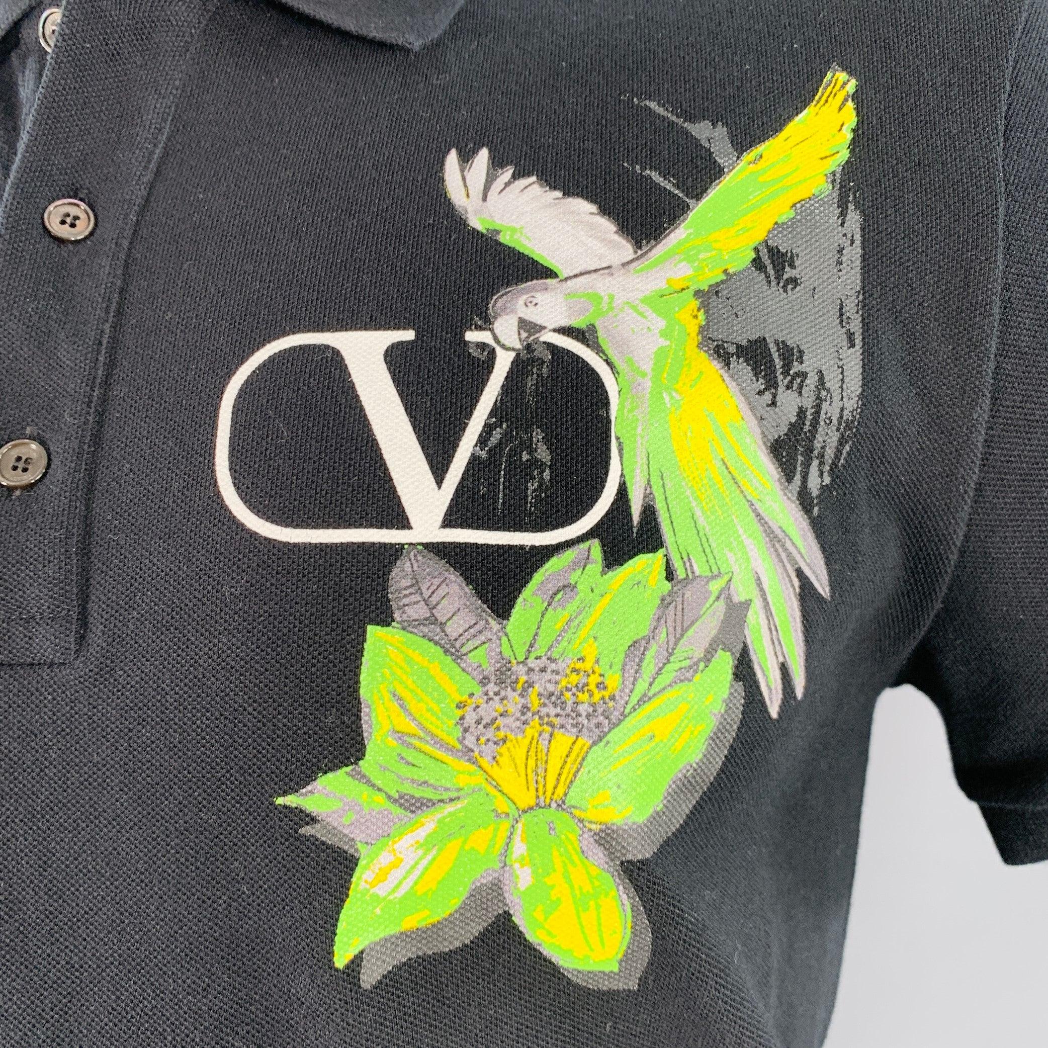 Polo VALENTINO
en piqué de coton noir, avec un imprimé graphique de perroquets vert néon et jaune et un logo V, des manches courtes et une demi-patte. 
fermeture à bouton. Fabriqué en Italie. Très bon état.
 Marques sur l'épaule. 

Marqué :   L
