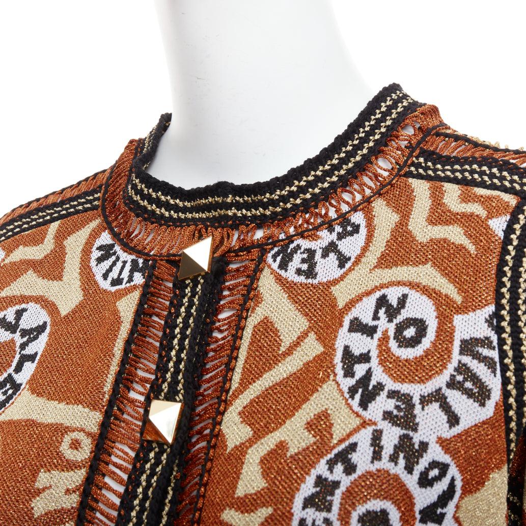 VALENTINO 2022 Rockstud Manifesto Bandana gold orange metallic lurex cardigan XS
Reference: AAWC/A01307
Brand: Valentino
Designer: Pier Paolo Piccioli
Collection: 2022 - Runway
Material: Fabric
Color: Gold, Black
Pattern: Logomania
Closure: