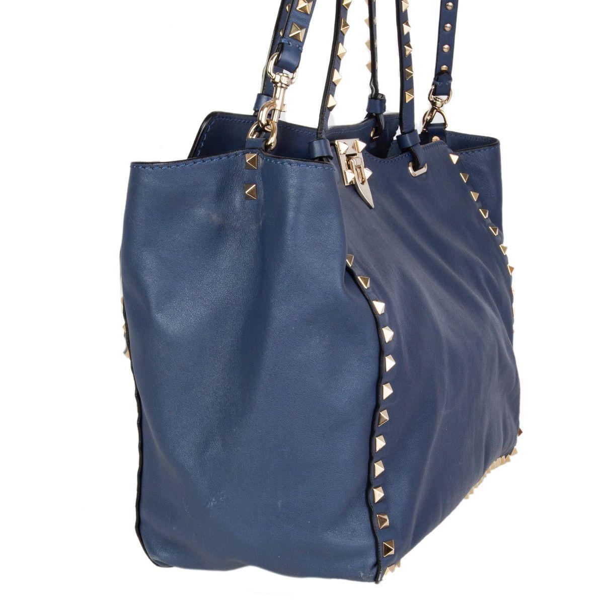 Valentino 'Medium Rockstud' shoulder bag in airforce blue calfskin featuring signature patinum-finish rockstuds in light gold-tone metal. Lined in off-white canvas with one zipper pocket against the back and two open pockets attached. Comes with a