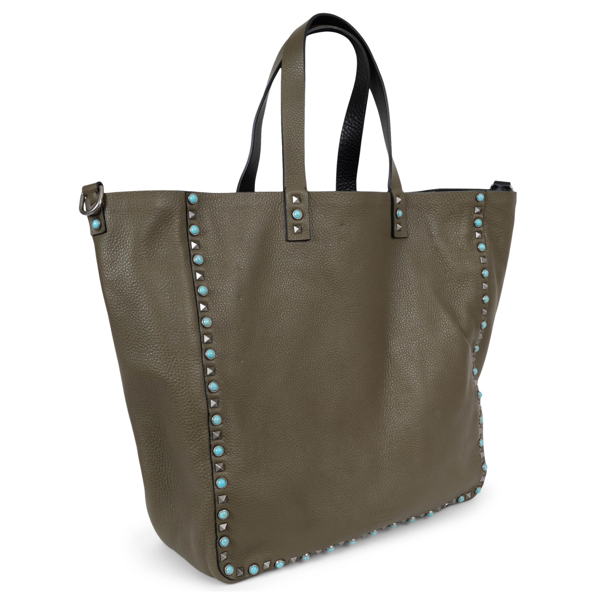 Diese 100% authentische Valentino Guitar Rockstud Rolling Wende-Tasche ist aus genarbtem Alce-Kalbsleder gefertigt und zeigt sich auf der einen Seite in Schwarz und auf der Rückseite in Militärgrün für ein vielseitiges Styling. Sie verfügt über