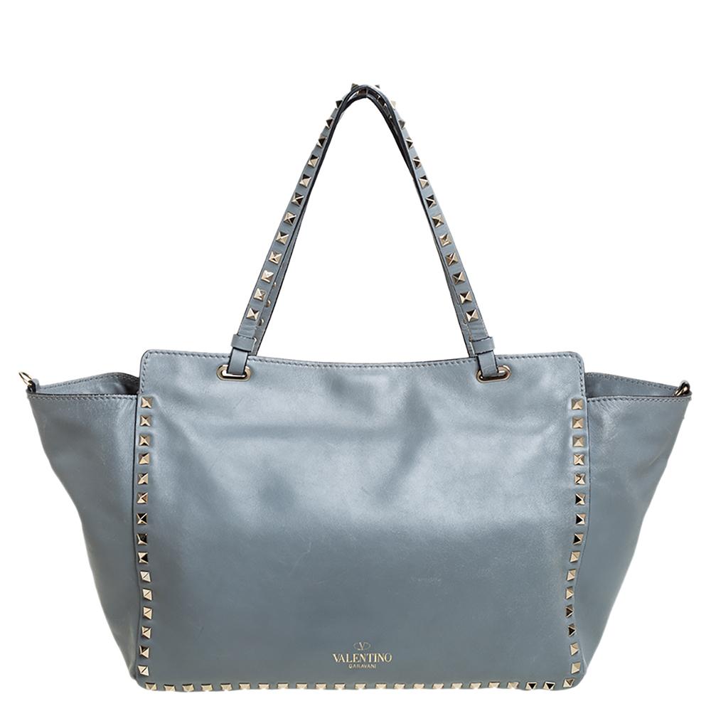 Luxury Italian fashion house Valentino is famed for its classic designs infused with its own signature modern edge and Rockstud details as showcased by this trapeze tote. Crafted from ash blue leather, it features top handles and a detachable